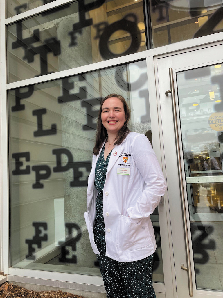Photograph of Shannon Hughes, an optometry student, standing in front of a storefront.