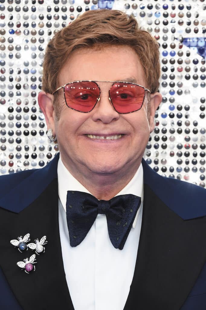 Photograph of Sir Elton John wearing red tinted lenses.