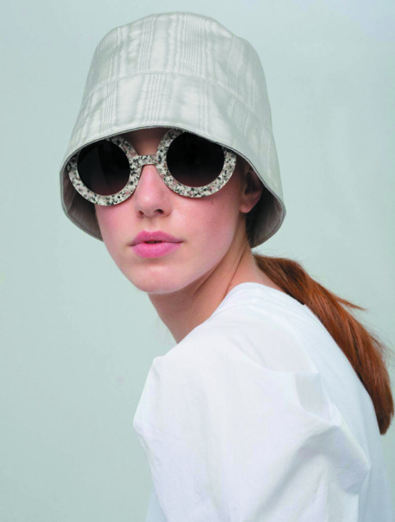 A model wearing chic 2023 Nina Mûr sunglasses with a speckled frame and oversized lenses.