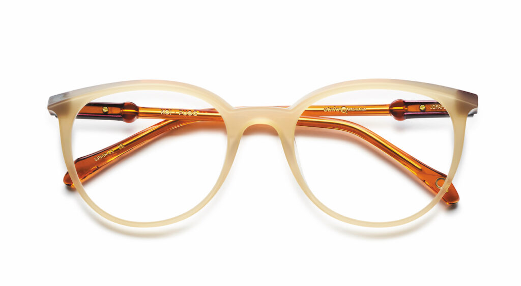 Close-up of elegant neutral-toned eyeglasses with detailed hinges.