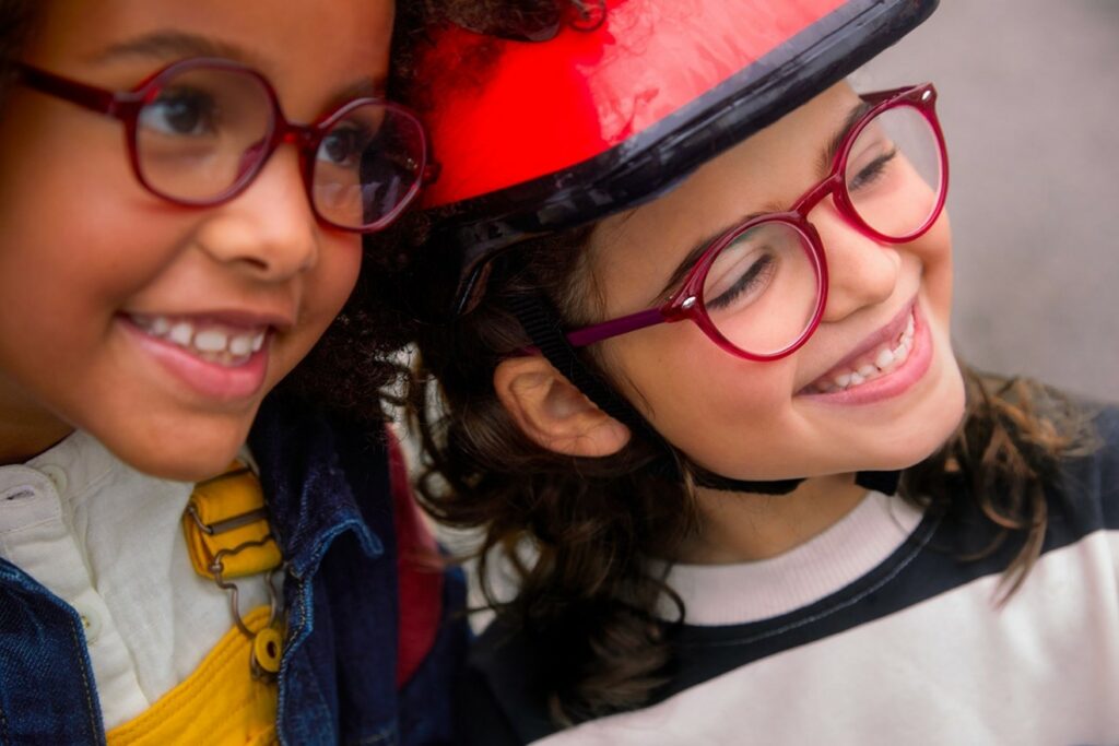 SightGlass Vision two little girls in bicycle helmets wearing glasses