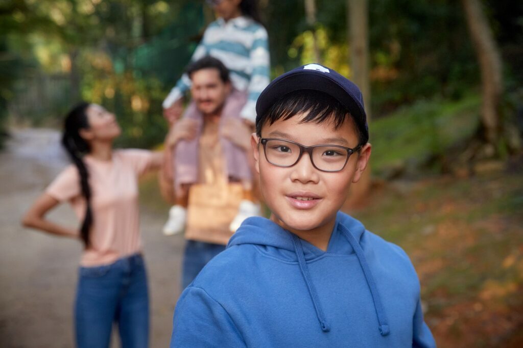 SightGlass boy wearing glasses with his family in the back